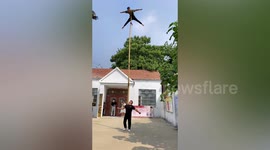 Acrobat climbs up 6-metre-long bamboo stick being held aloft by friend