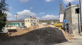 Palestinian protesters use shovels in their attempt to break down an Israeli dirt barrier erected to lock down Nablus