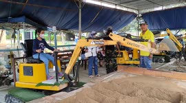 Children learn to operate scraper machine in Malaysia