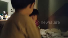 Siblings happily playing jumping on bed