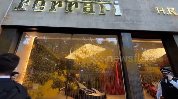 Workers clean windows of Bentley and Ferrari businesses after Just Stop Oil sprayed them with orange paint
