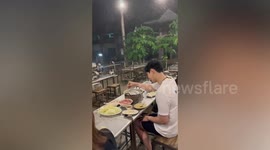 Hungry customer carries on eating meat during harsh thunderstorm