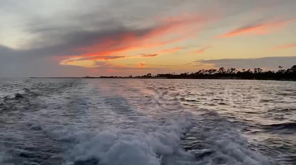 On a sunset cruise in florida I film the back of the boat making waves as we cruise along, during sunset.
