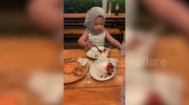 Hungry toddler continues eating barbecue oblivious to thunderstorm