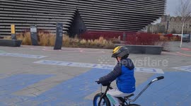 Child learning to cycle around V & A in Dundee