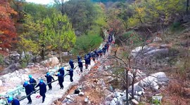 Dozens of workers carry 145-tonnes of cables up mountain in China