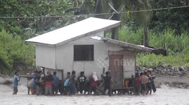 Hero neighbours carry friend's home through RIVER during tropical storm