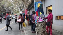 People dress trees in Shanghai with colourful knitwear