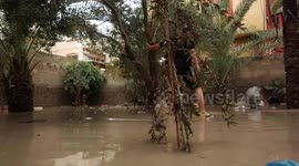 Palestinians remove rainwater from a street flooded by rain water, at el- Shati refugee camp