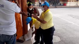 Police carry heavy sacks of coins donated by Buddhist monks in Thailand