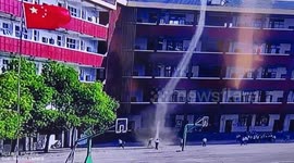 Pupils chase dust devil on playground in China