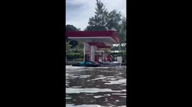 Man refuels jet ski during floods at regular gas station