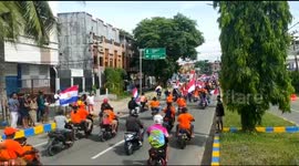 Motorbike-riding football fans in West Papua ride in convoys with the flags of their chosen World Cup teams