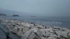 Waves break on the seafront of Mergellina with the Castel dell'Ovo in Naples in the background. After months of heat and drought, heavy rains and thunderstorms hit the whole of Italy and Southern Italy, creating damage, inconvenience to the population and
