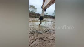 Excavator used to rescue man trapped in muddy pond in China