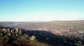 Aerial view of Cow and Calf, Ilkley, West Yorkshire, during icy cold weather in the UK yet bright blue skies.