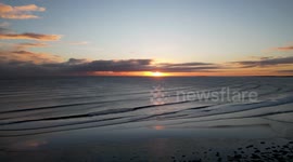 Aerial drone footage of beautiful sunrise over Alnmouth Beach in Northumberland, England during Arctic Blast
