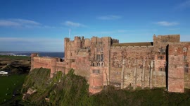 Epic aerial footage of Bamburgh Castle, featured in upcoming Indiana Jones movie, on a bright sunny afternoon.