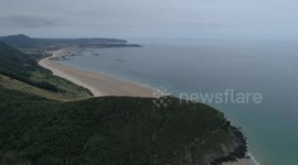 Flying over and near impressive cliffs in Laredo at sunset with danger by drone