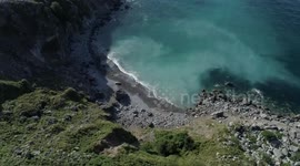 Flying over and near impressive cliffs in Laredo at sunset with danger by drone