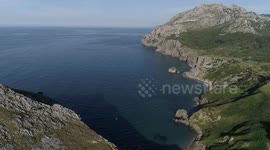 Flying over and near impressive cliffs in Laredo at sunset with danger by drone