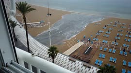 Motionlapse of rainwater flooding onto Levante Beach and washing away the sand in Benidorm, Spain