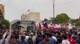 Protesters block the street outside Peru’s congress building. Police fire tear gas in response