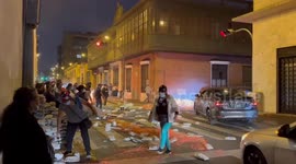 Protesters light fires and throw rocks into the road during protests in Lima’s historic centre