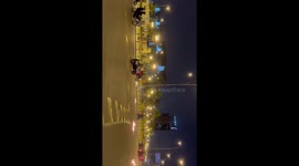 Riot police in motorbikes drive past fires lit by protesters in Central Lima