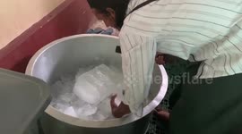 Burmese locals mix bright green cream soda drink in giant vat