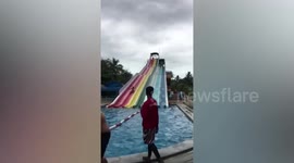 Tourist switches lanes while gliding down waterpark in Thailand