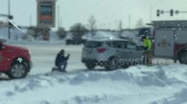 Man inspects damage to his vehicle after being rear ended.