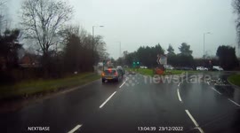 Dashcam footage of driver swerving in front of a vehicle to avoid small standing water on road