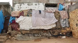 Palestinian woman Muisser Al-Jamal, 55, with her grandchildren gather around a fire to warm themselves during a cold day