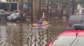 Man canoes through flooded road in Seattle, US