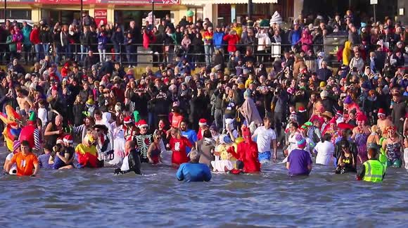Crowds gather to cheer on new years day dippers at a North Yorkshire seaside town.