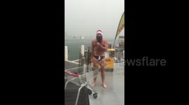Man in underwear and santa hat does mock weather report amid Sydney storms
