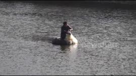 Man fishes in canal on self-made canoe