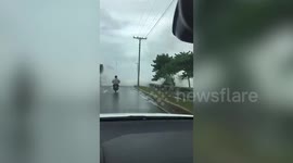 Motorcycle rider knocked off bike by huge wave in Dominican Republic