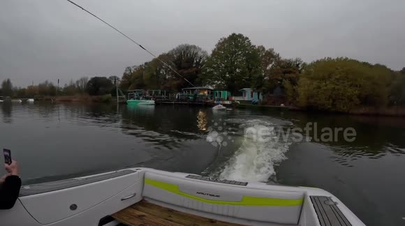 Daredevil surfs on ironing board dragging boat in UK