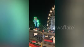 Thrilled youngsters bounce wildly inside extreme spinning bowl ride at fairground