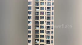 Woman balances on ledge without harness to clean 15th-floor window