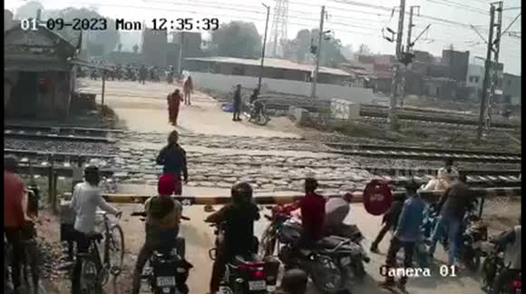 Reckless rider narrowly escapes TWO speeding trains at level crossing in India