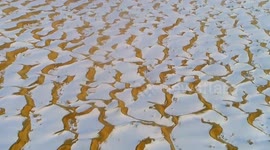 Rare snow gives dunes in China's largest desert frosted tops