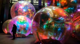 Iridescent giant bubbles in London create stunning scene at night
