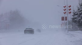 Cars drive through heavy snow, rough conditions in Weihai, China