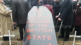 Family members of Bloody Sunday victims and MPs gather on Parliament Square with coffin to mark anniversary