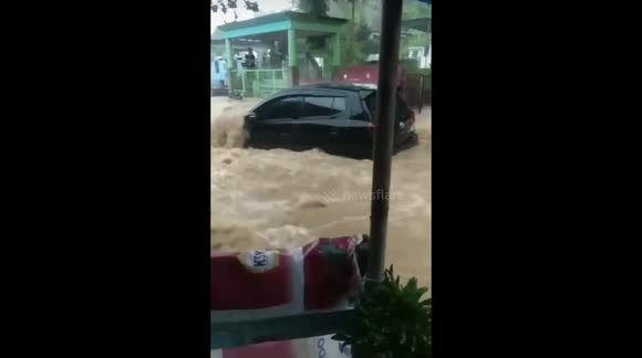 Homes and cars dragged away by flood water in Manado, Indonesia