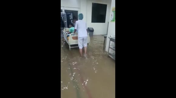 Indonesia: Hospital staff walk through ankle-deep floodwater as they evacuate patients