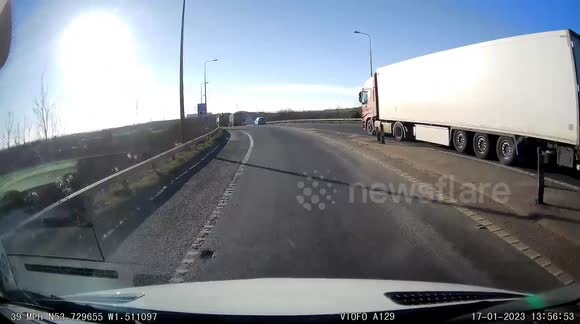 Impatient angry car driver undertakes tipper truck and brake checks them nearly causing accident on M1 motorway slip road